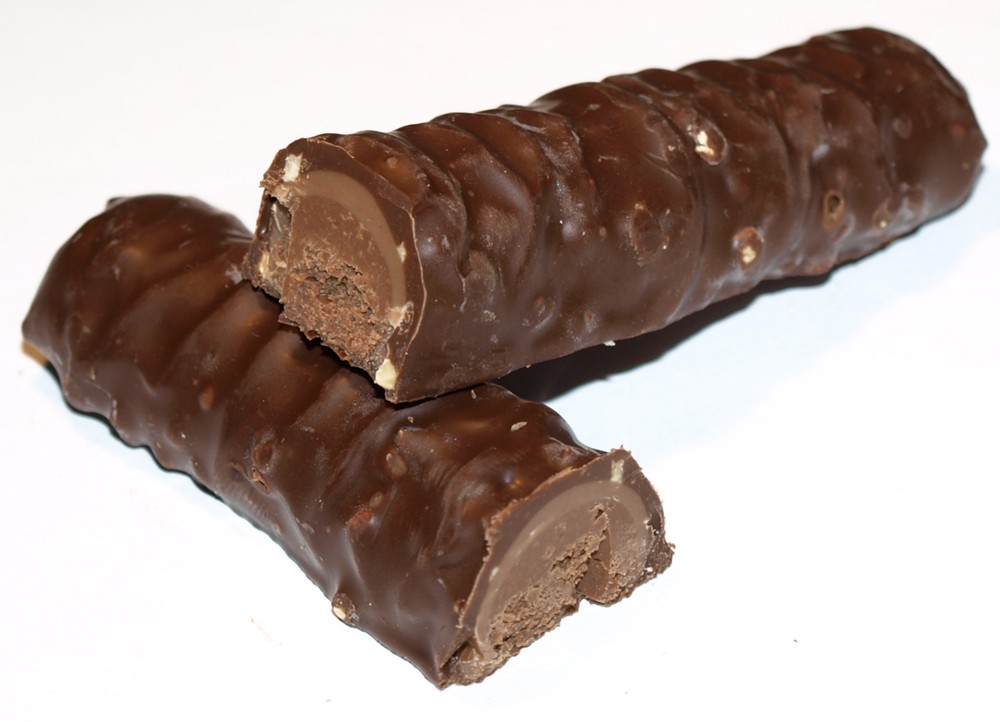 a chocolate bar is cut into four segments and ready to eat