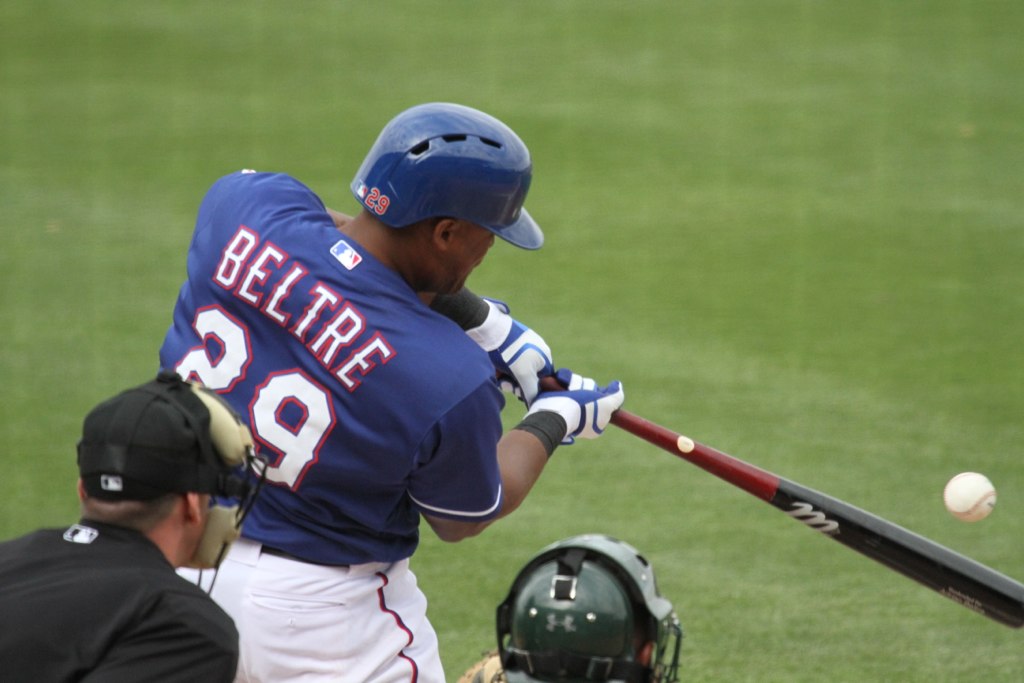 a baseball player swinging his bat towards a ball