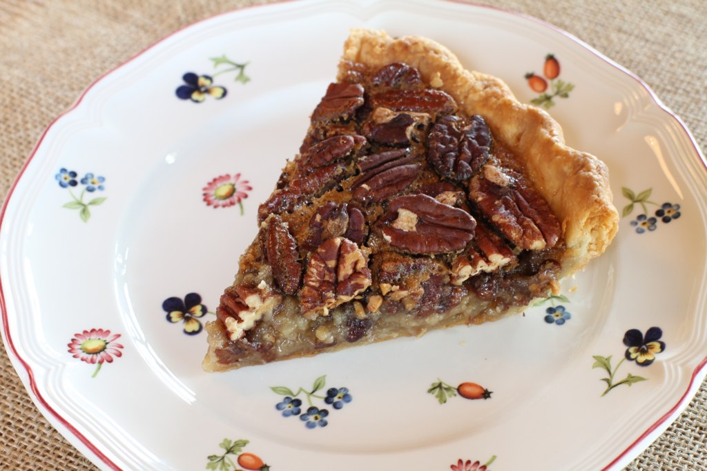 there is a slice of pecan pie on a plate