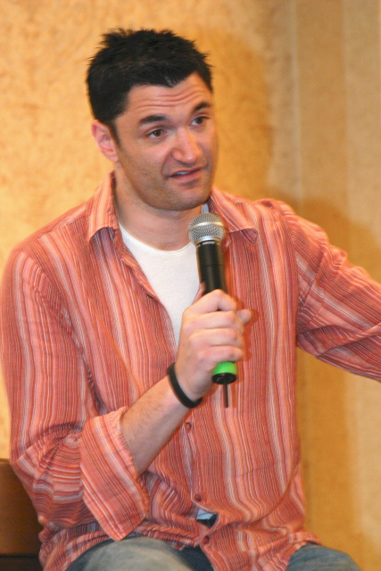 a man talking into a microphone holding soing