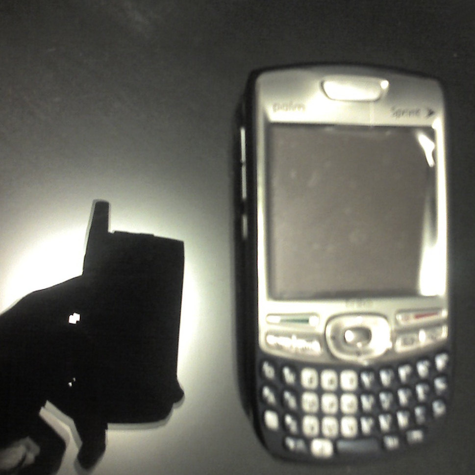 a cell phone that is placed next to a piece of plastic