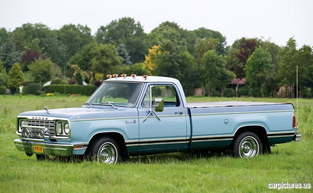a pick up truck parked on top of a green grass covered field