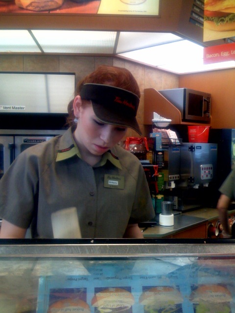 a little boy that is behind a sandwich counter