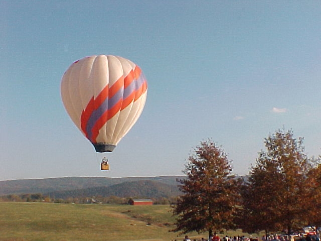 a very big and colorful  air balloon being flown