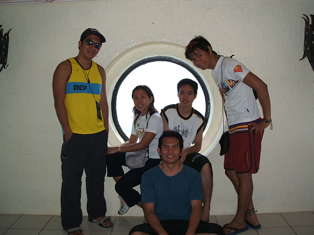 a group of men and women standing around a round window