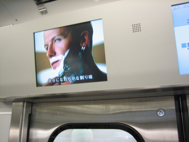 there is a picture of a man on the screen above a subway door