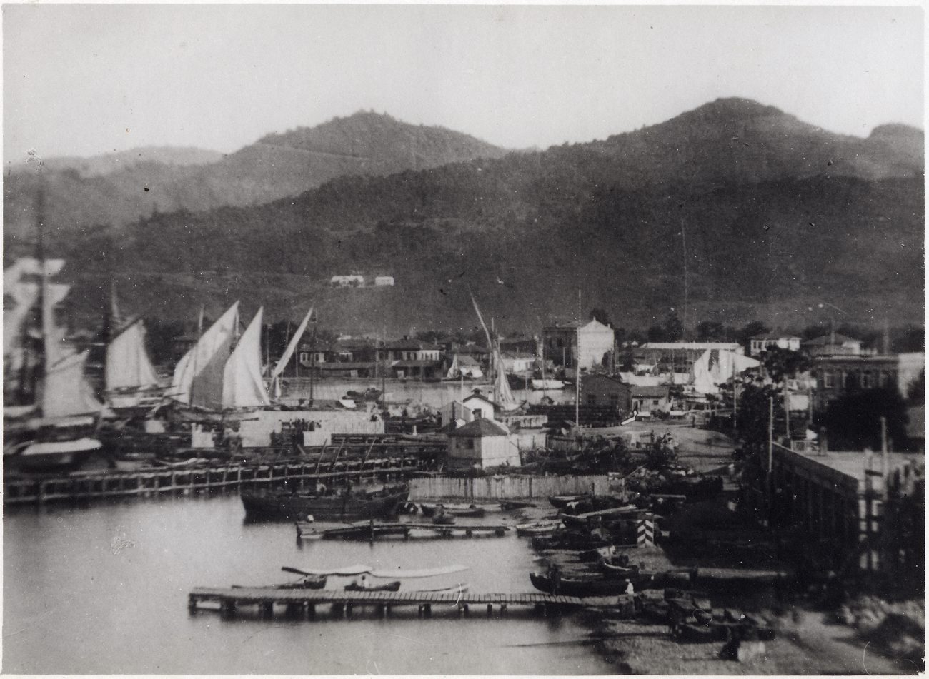 an old black and white po of several sail boats docked in a harbor