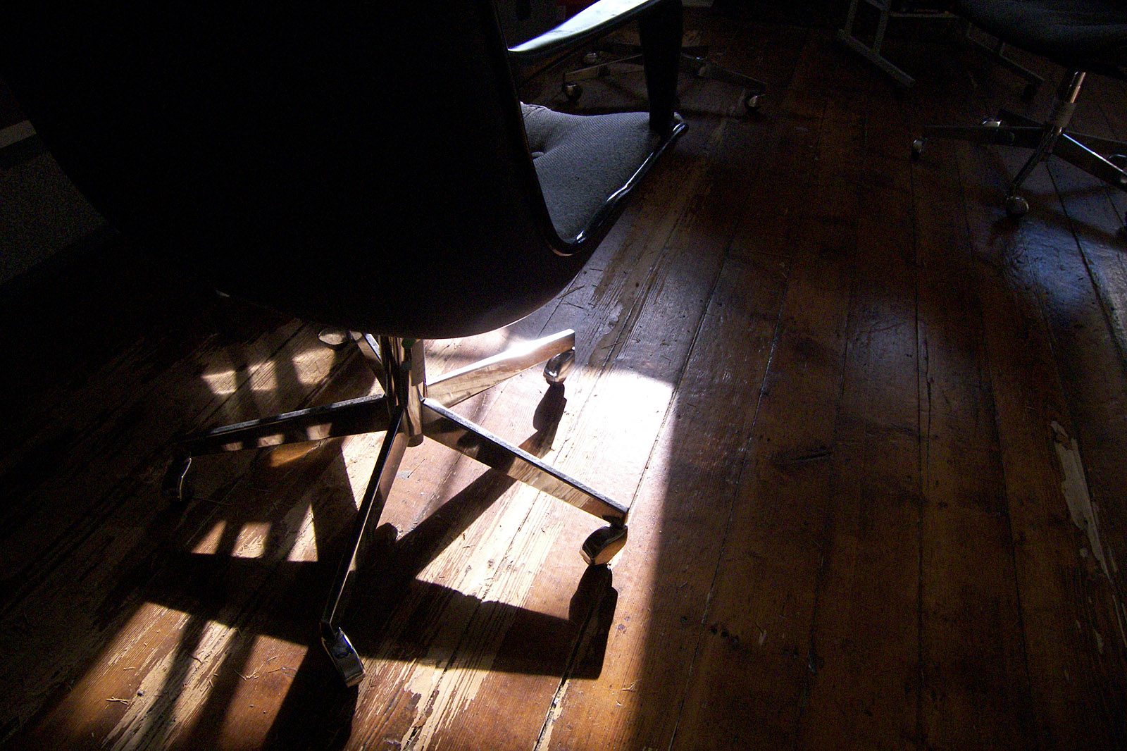 the sun is shining in the dark room with chairs