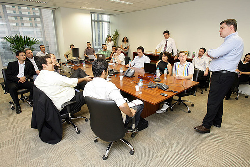 a group of people at desks are gathered