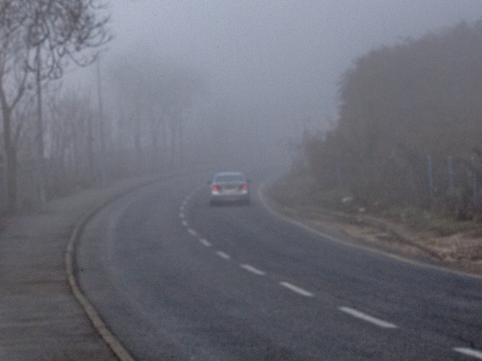 car driving down a road in the mist