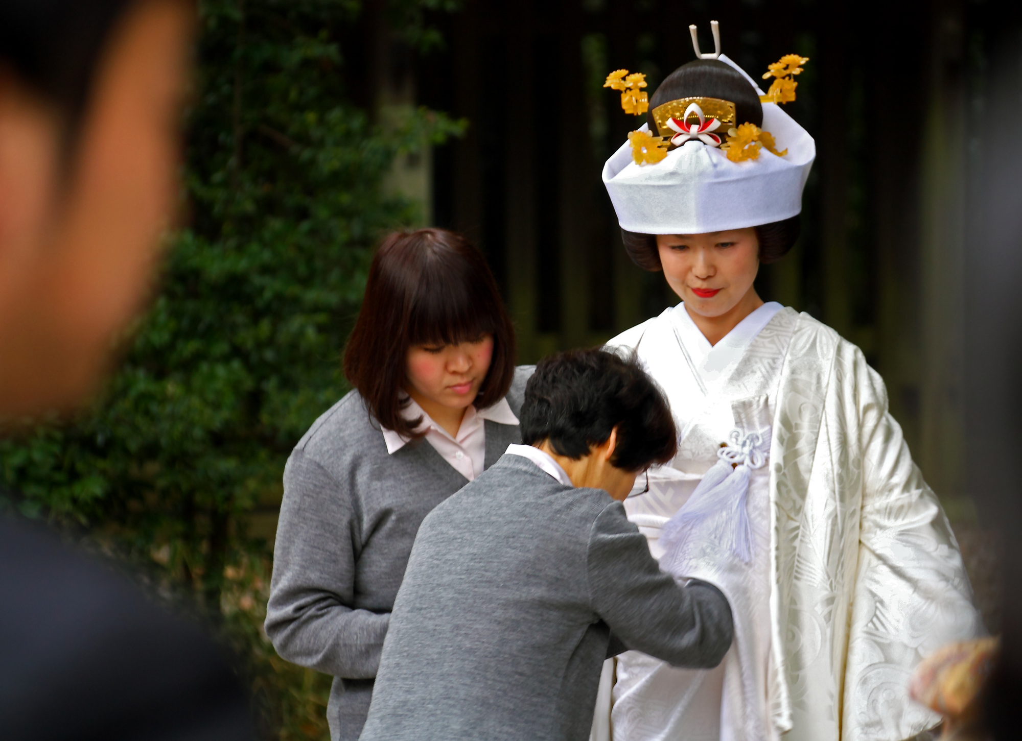 two women and a man wearing korean clothing in the park