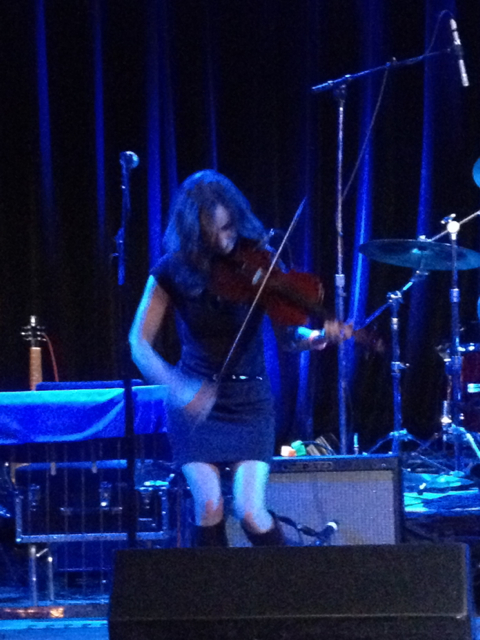 the woman is playing the violin on stage