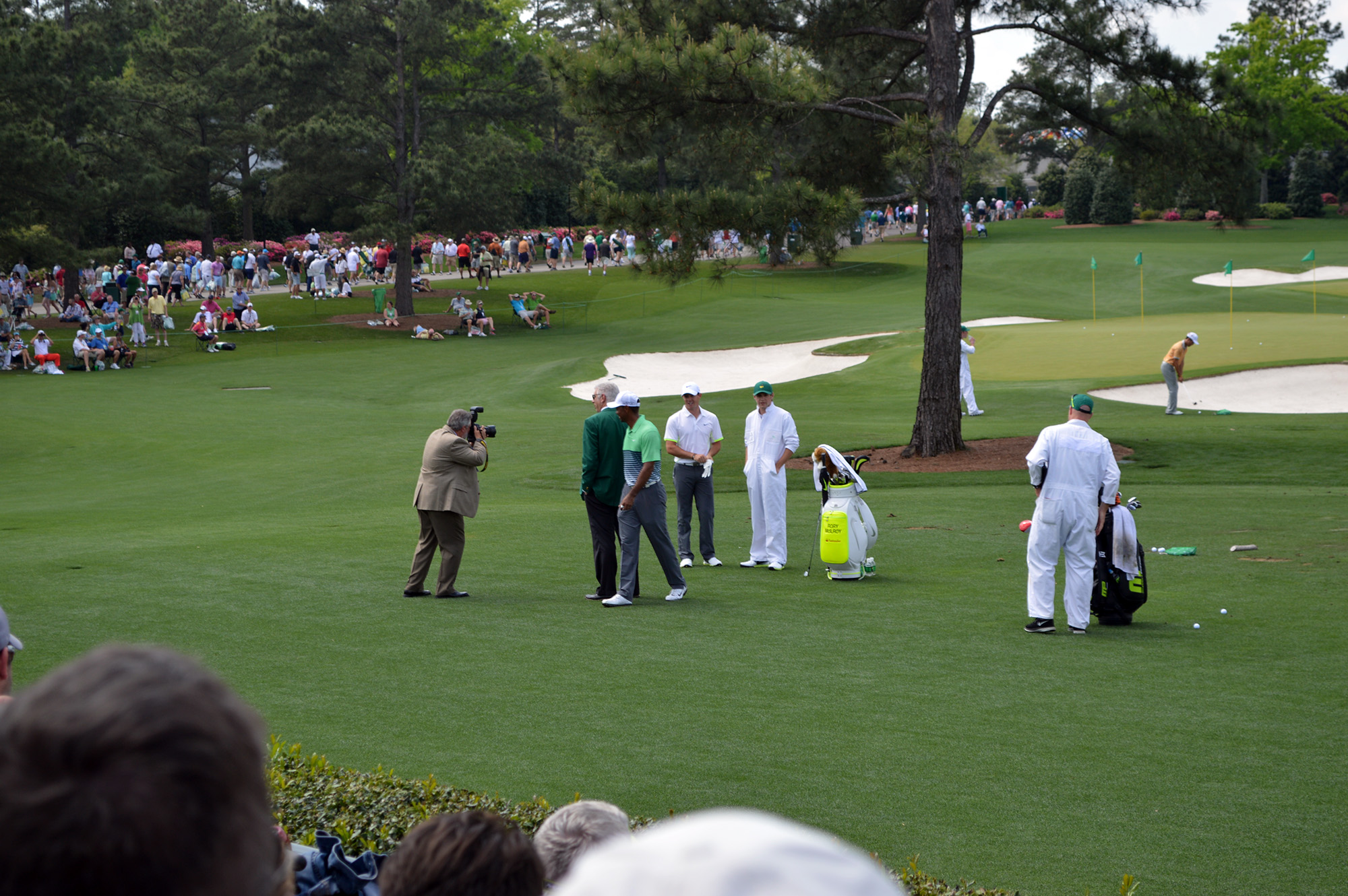 some golf players and a referee on a putting green