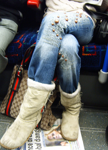 a woman is wearing boot boots and sitting on a magazine
