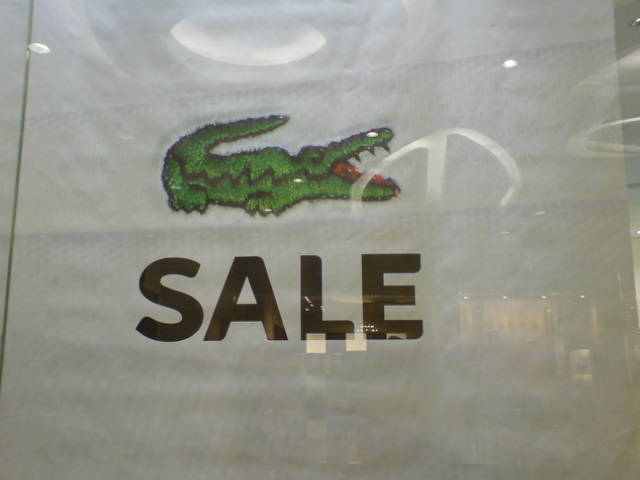 a logo of a crocodile head on display in a store window
