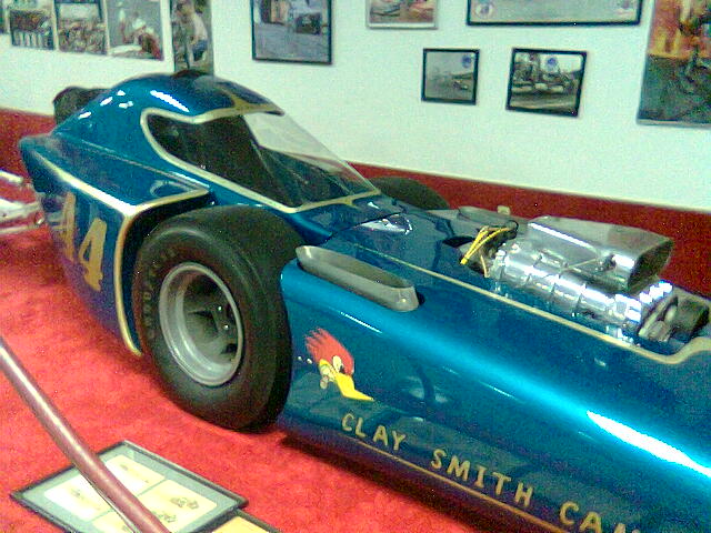 an old style racing car on display in a museum