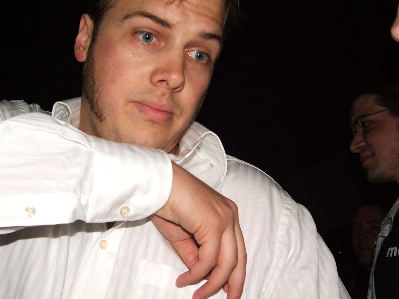 a man wearing a white shirt holding his elbow