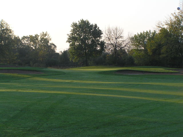 a view of a golf course at sunset