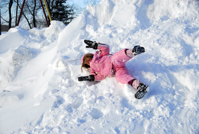 a young woman lays down in a snow pile