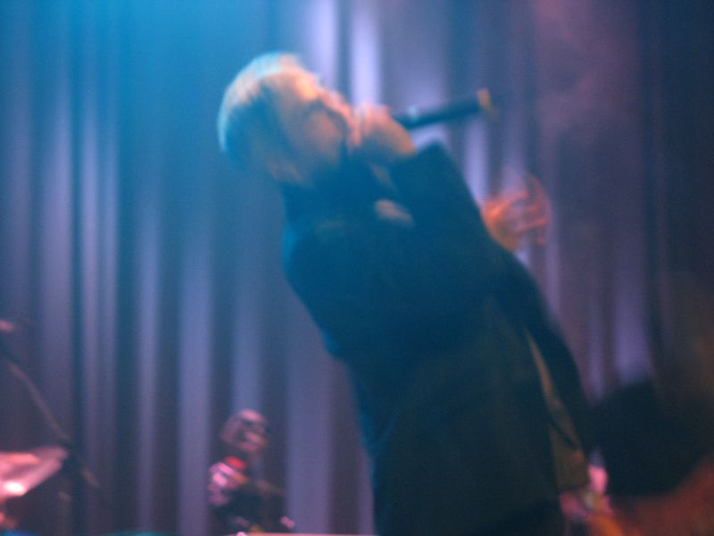 a woman on stage with her hands raised in the air