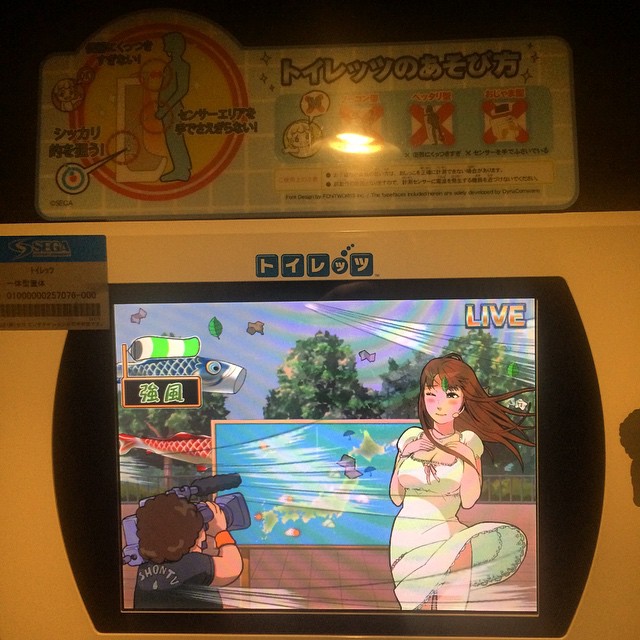 someone standing near a cartoon arcade screen playing a game