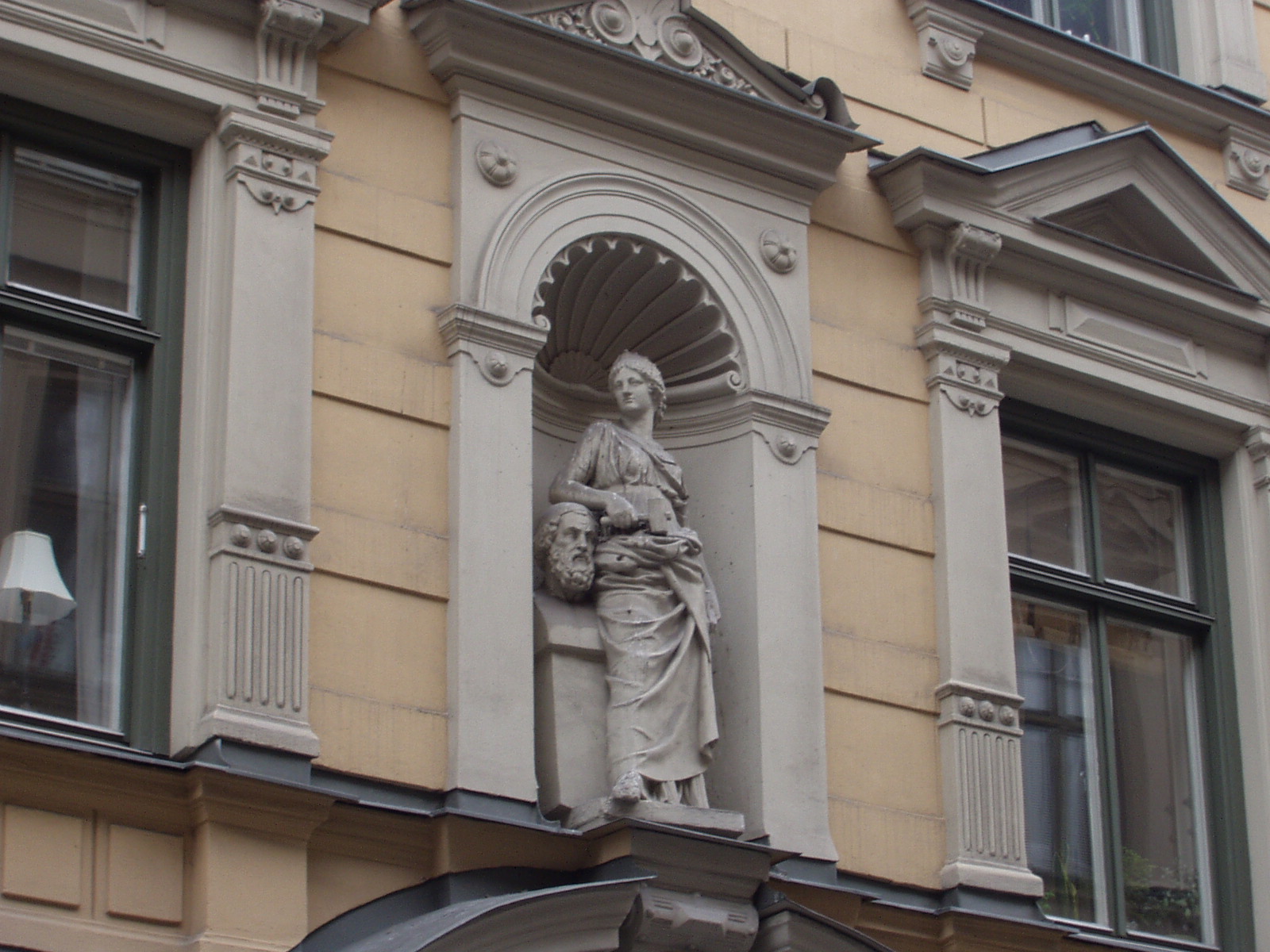 statue on a building near a window with windows