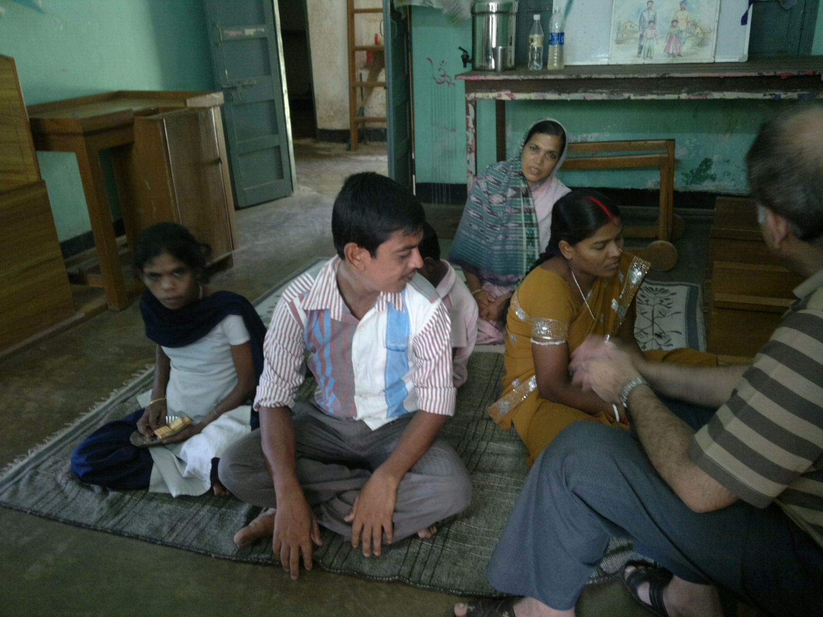 a group of people sitting on the floor in an empty room