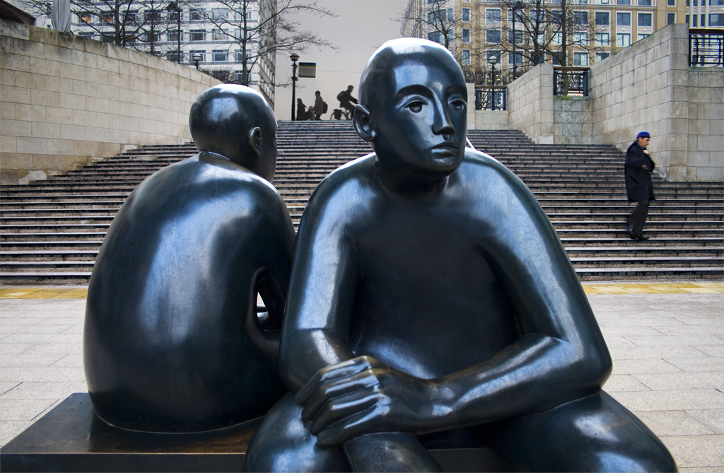 a statue of a woman and man sitting on top of a wooden box