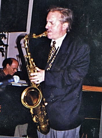 man playing saxophone while another man plays the guitar