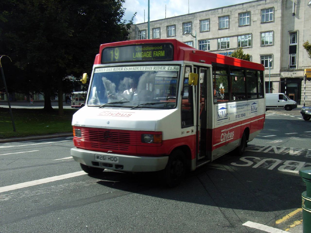 a white and red bus traveling down a street