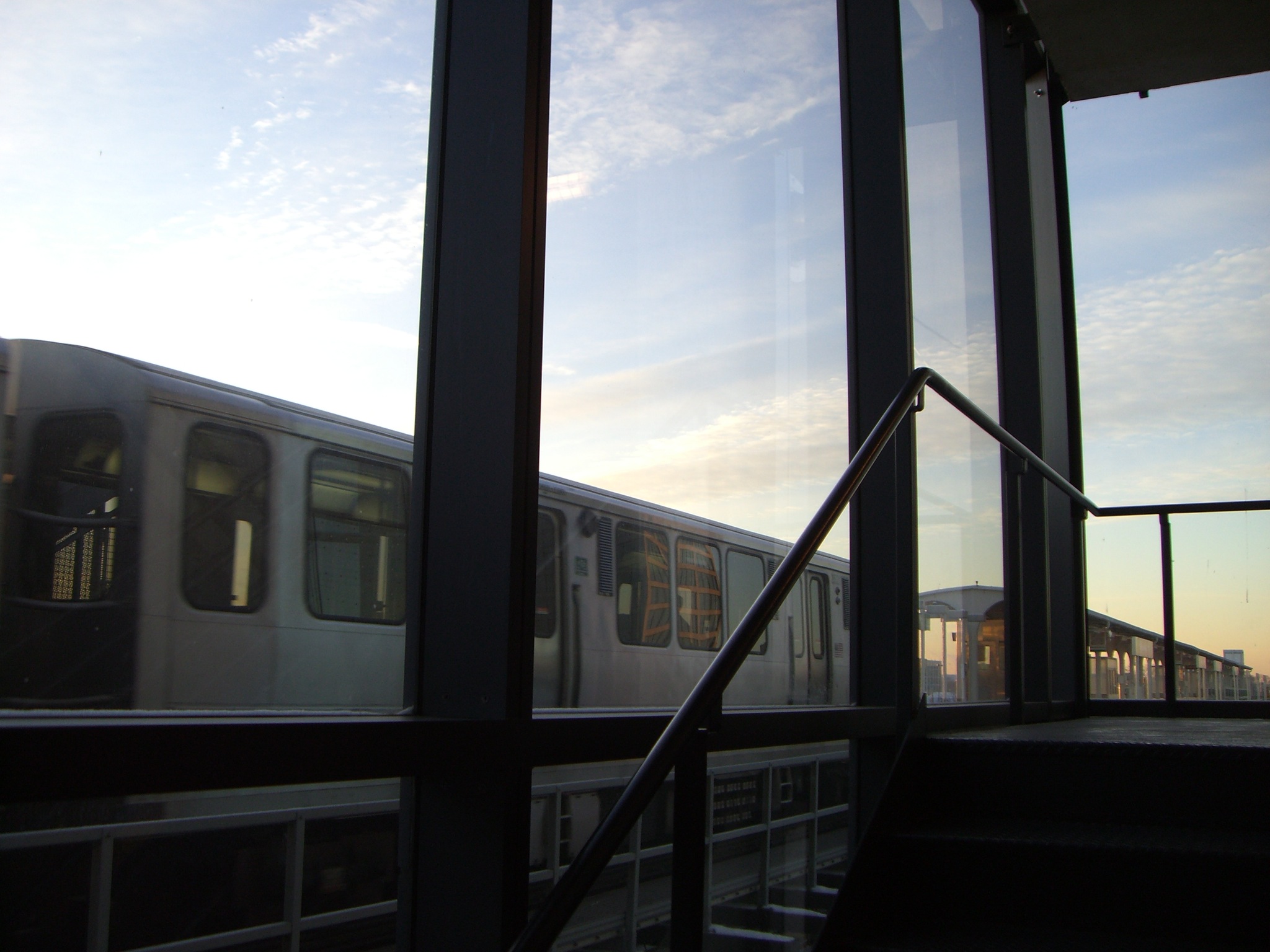 a subway train going past a rail with stairs