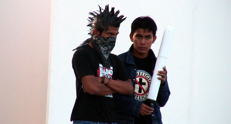 two men are holding things with one man wearing a horned helmet