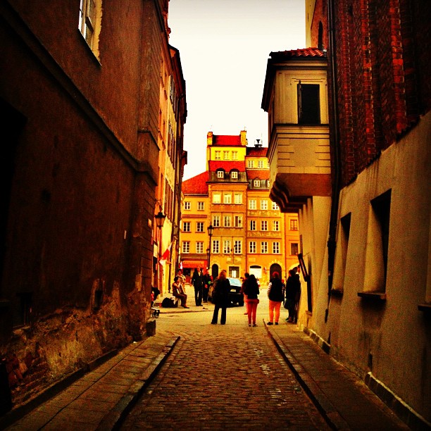 two narrow alleys with people walking down the side
