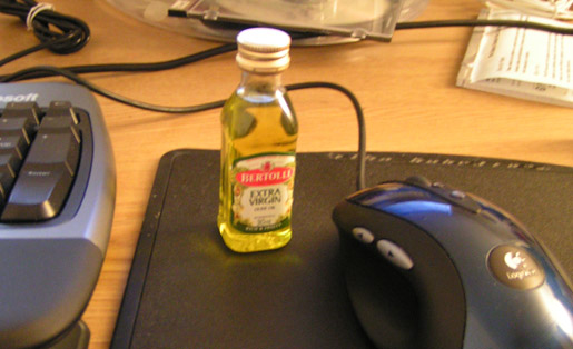 a bottle of alcohol sitting next to a computer keyboard
