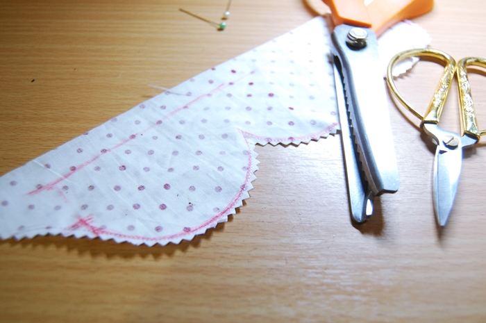 scissors and thread on a wooden surface with dots