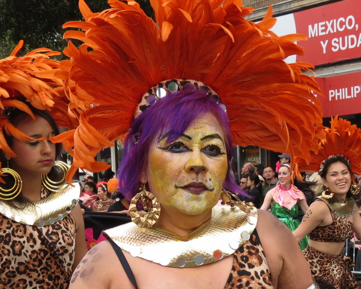 women with colorful makeup and feathers are in the street