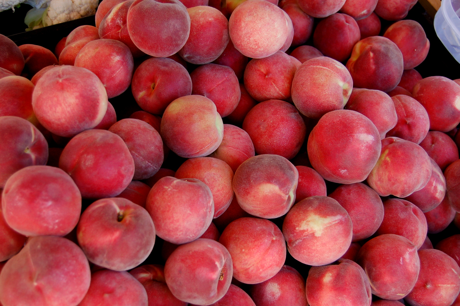 closeup po of pink peaches in display at market