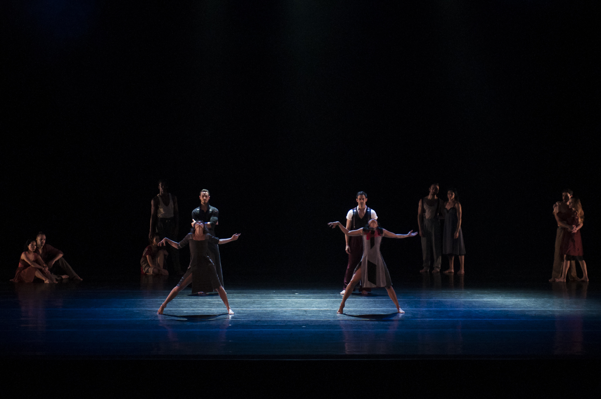 three dancers on stage are standing with one another