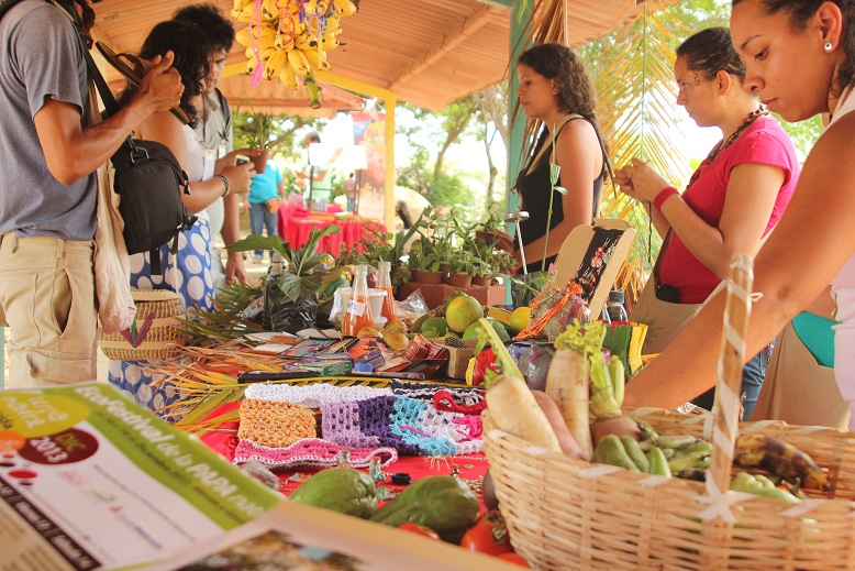 the people are at the fruit and vegetable stand