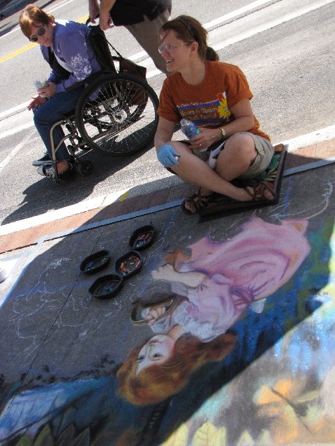 a girl is drawing graffiti on the sidewalk