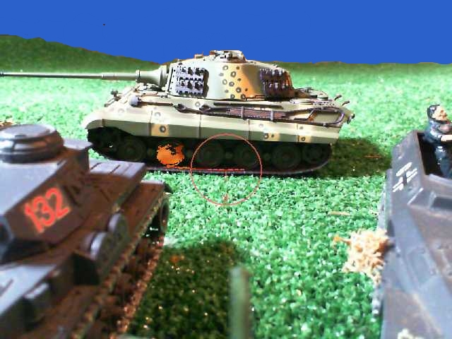 a small model tank sitting in a grassy field