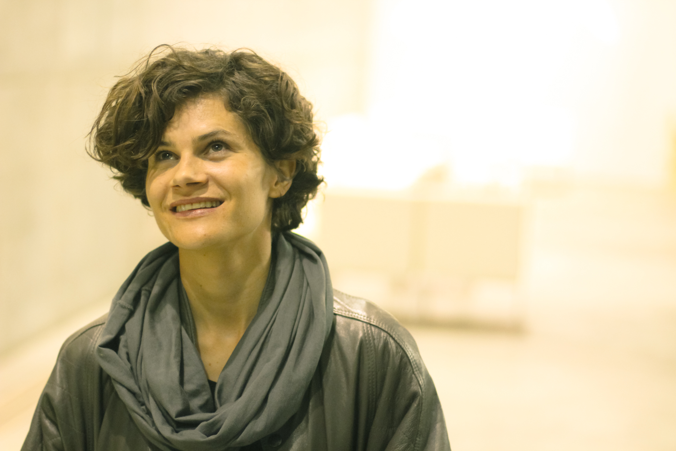 a woman with curly hair smiles at the camera