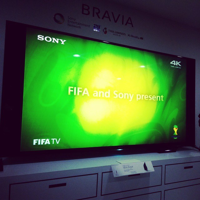 a television screen in a room displaying the logo for sony