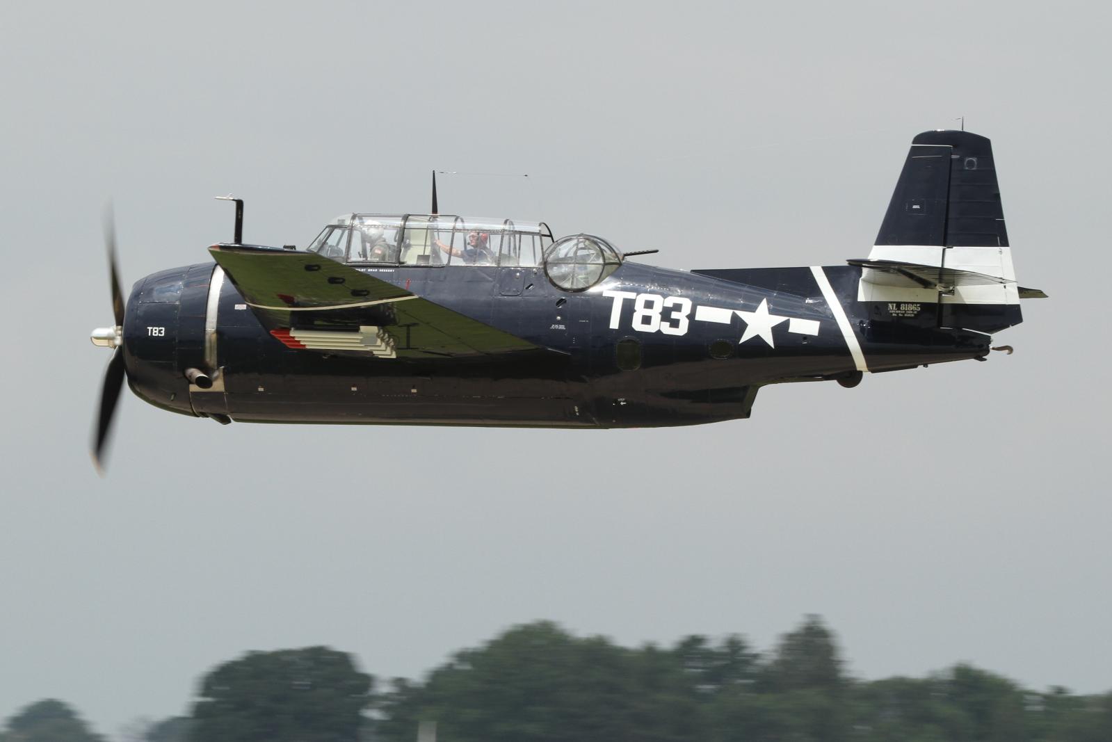 a black and green plane is flying close to the camera