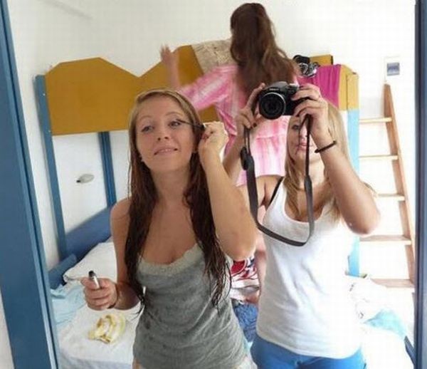 a woman takes a selfie in front of a mirror