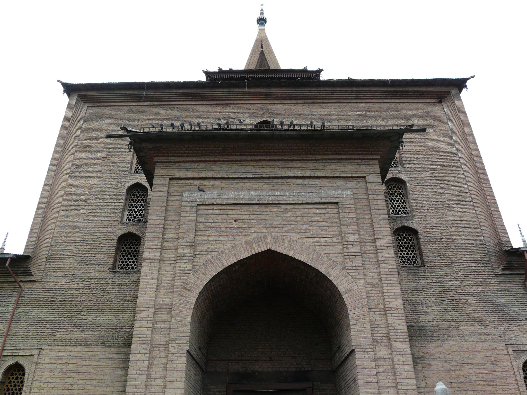 a tall grey brick structure with arched doors