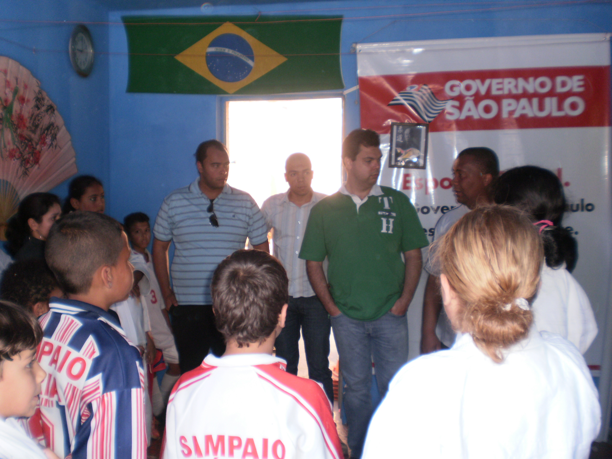 two men and three men are speaking to a group of other people