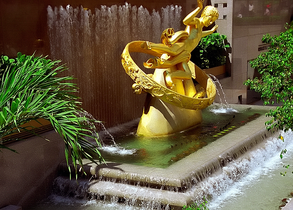 a large fountain with a gold sculpture at the base of it