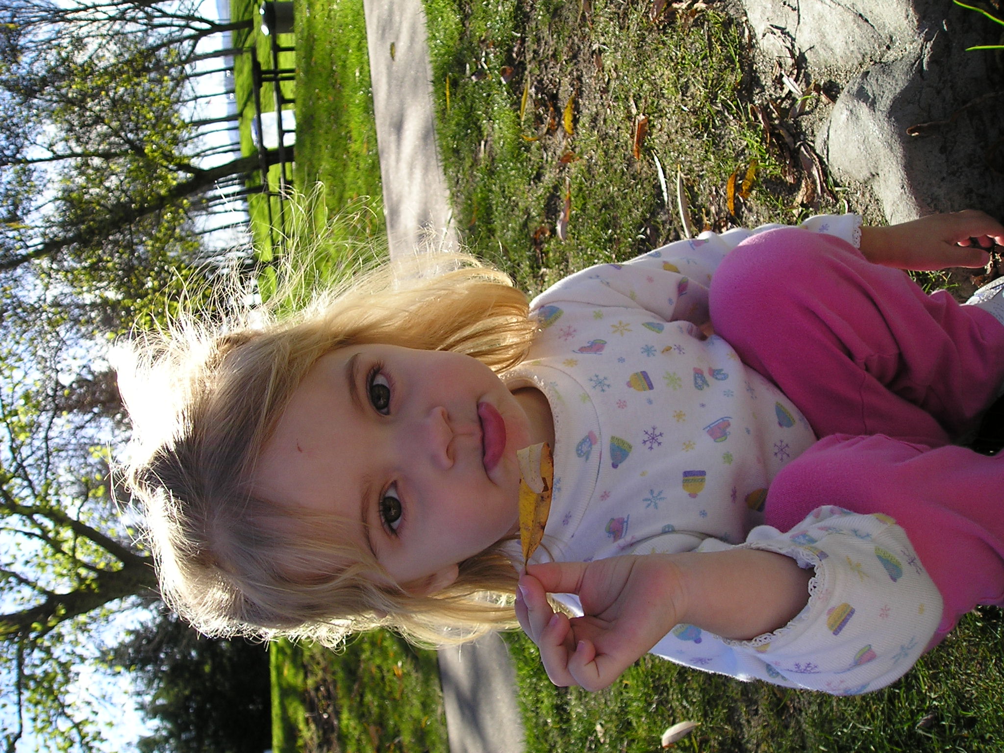 a child in pink holding soing in her mouth