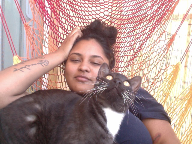 a woman with her cat laying in a hammock